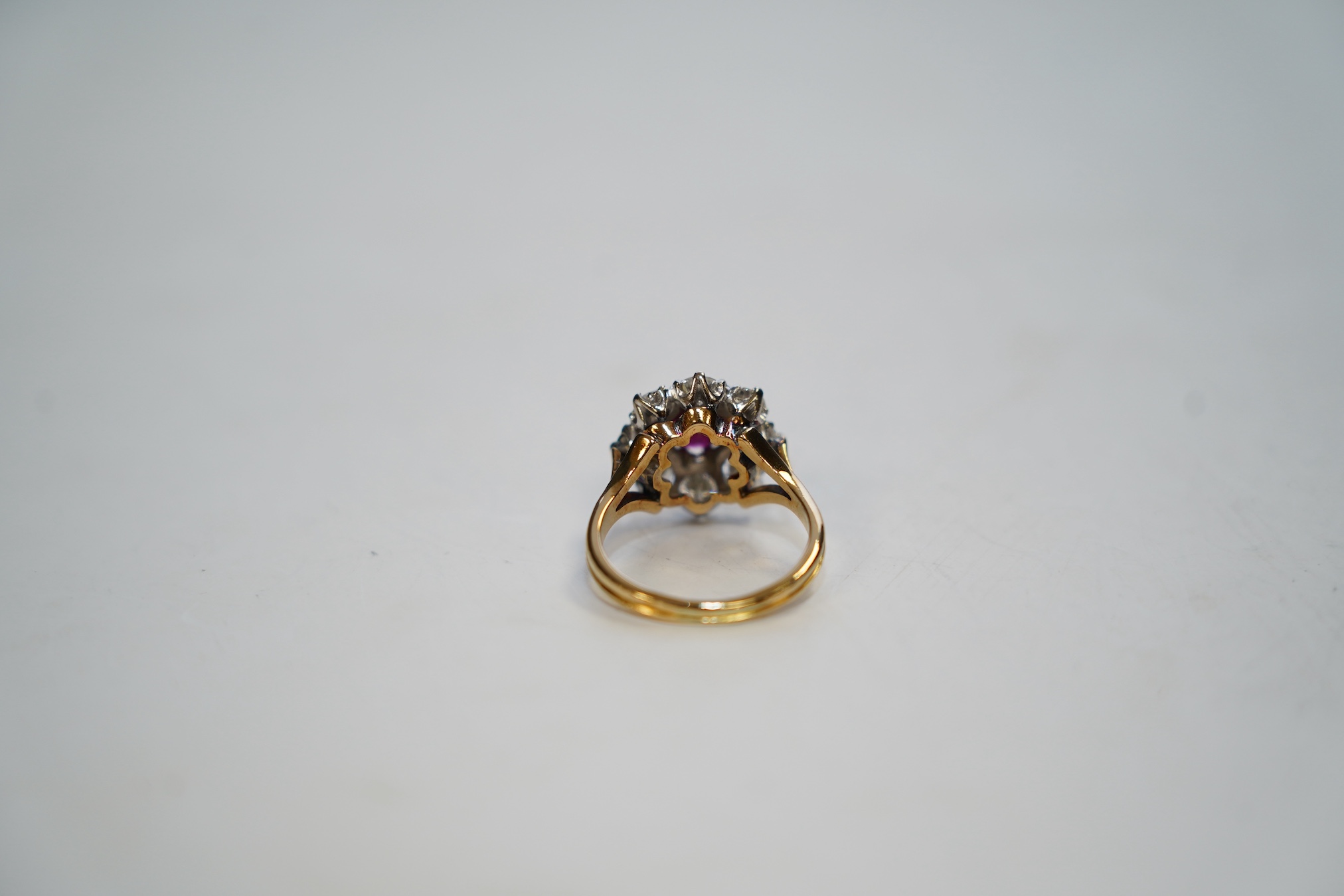 An 18ct gold, single stone ruby and eight stone diamond set flower head cluster ring, size P, gross weight 6.5 grams. Condition - fair